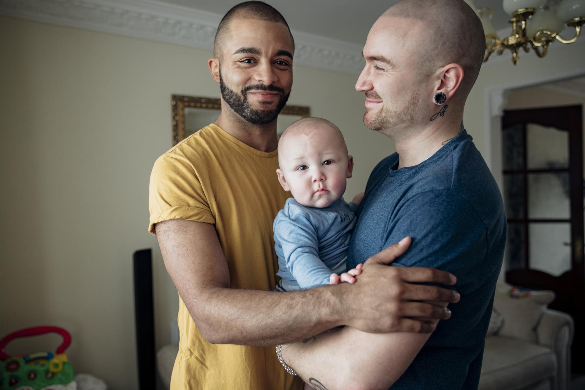 A couple holding their infant between them